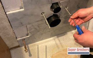 technician mounting the toilet to the wall