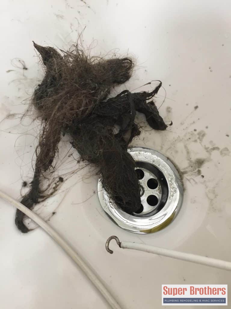 Drain cleaning bathroom sink with a lot of hair