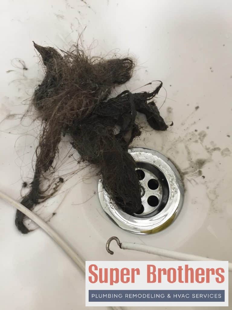 Drain cleaning bathroom sink with a lot of hair