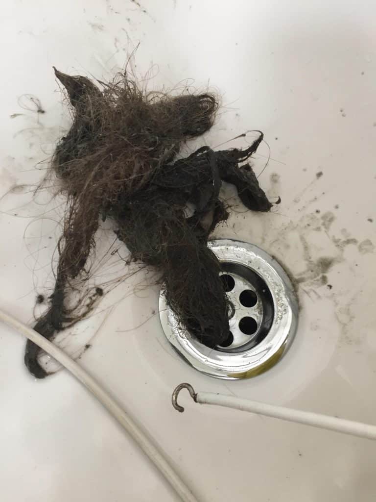 Drain cleaning bathroom sink with a lot of hair