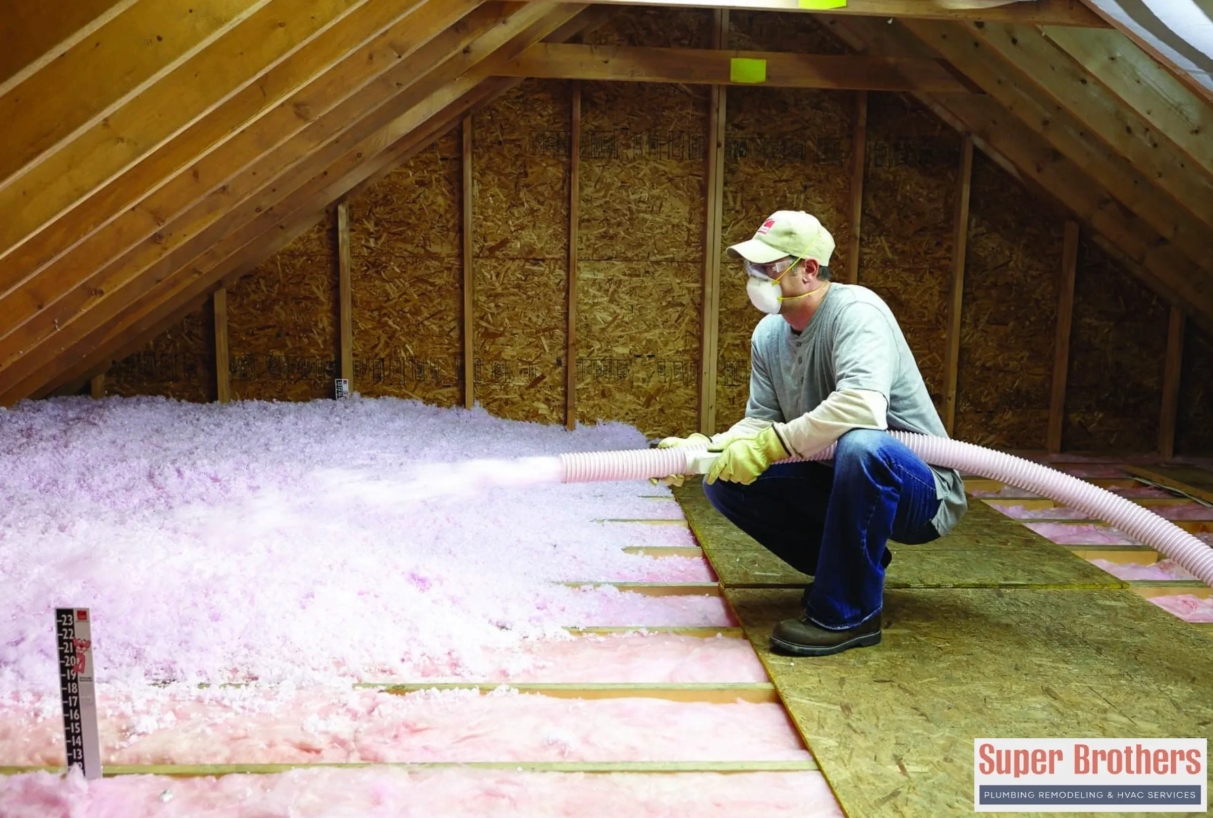 technician is blowing the insulation in the attic