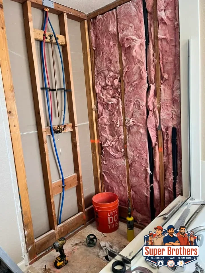 Licensed plumber routing flexible PEX water lines through residential framing
