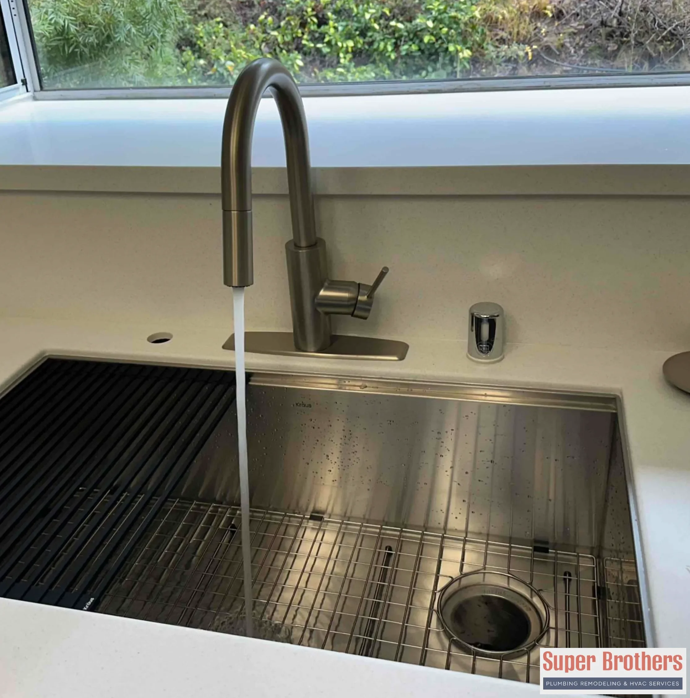 Homeowner testing hot water at a kitchen sink after recirculation pump installation