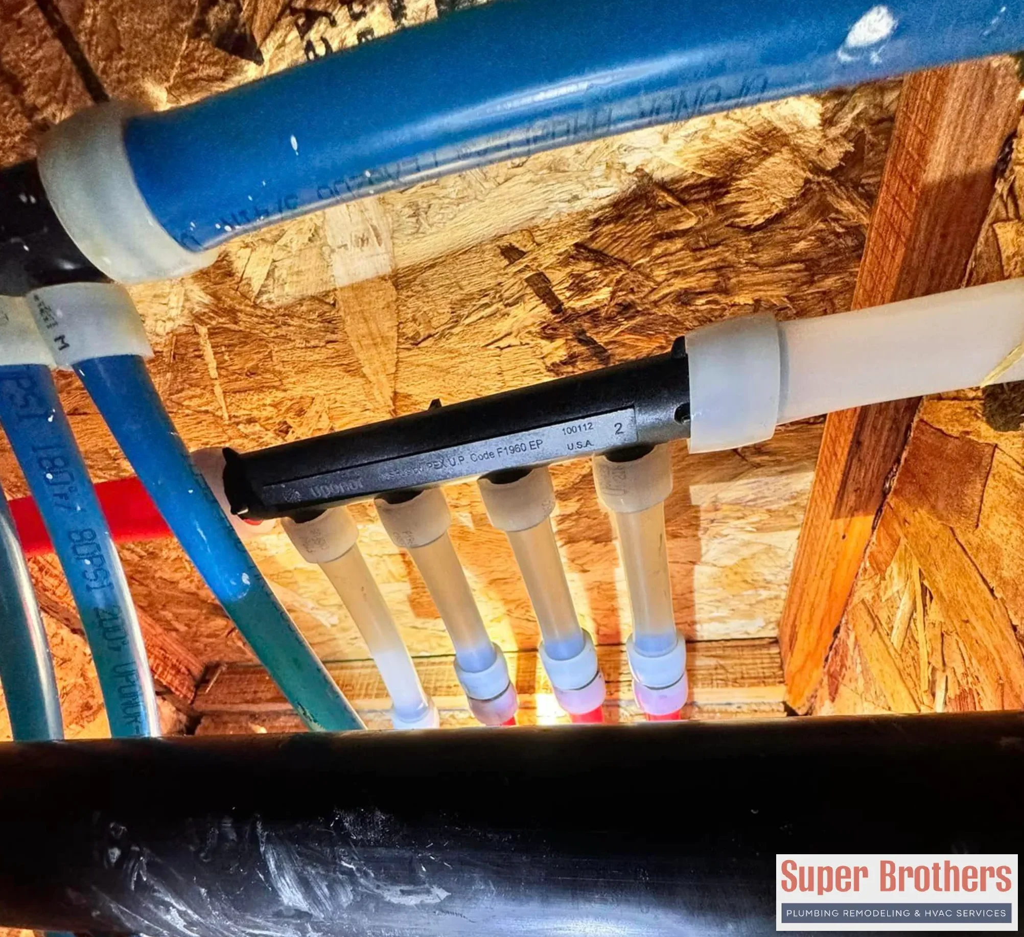 New red and blue PEX water lines installed in a home utility area