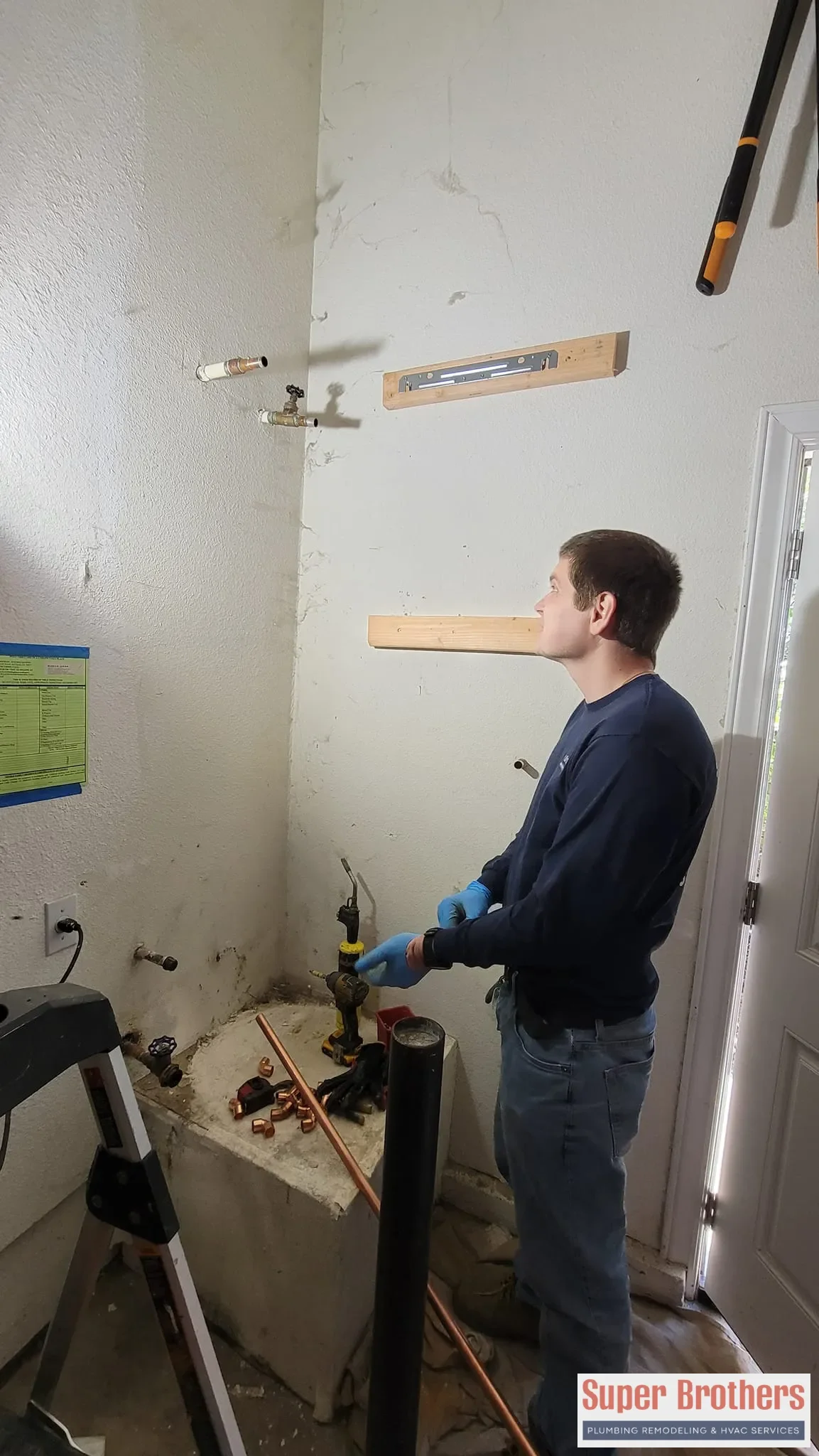Plumber measuring water heater connections for a tankless installation in Mountain View, CA