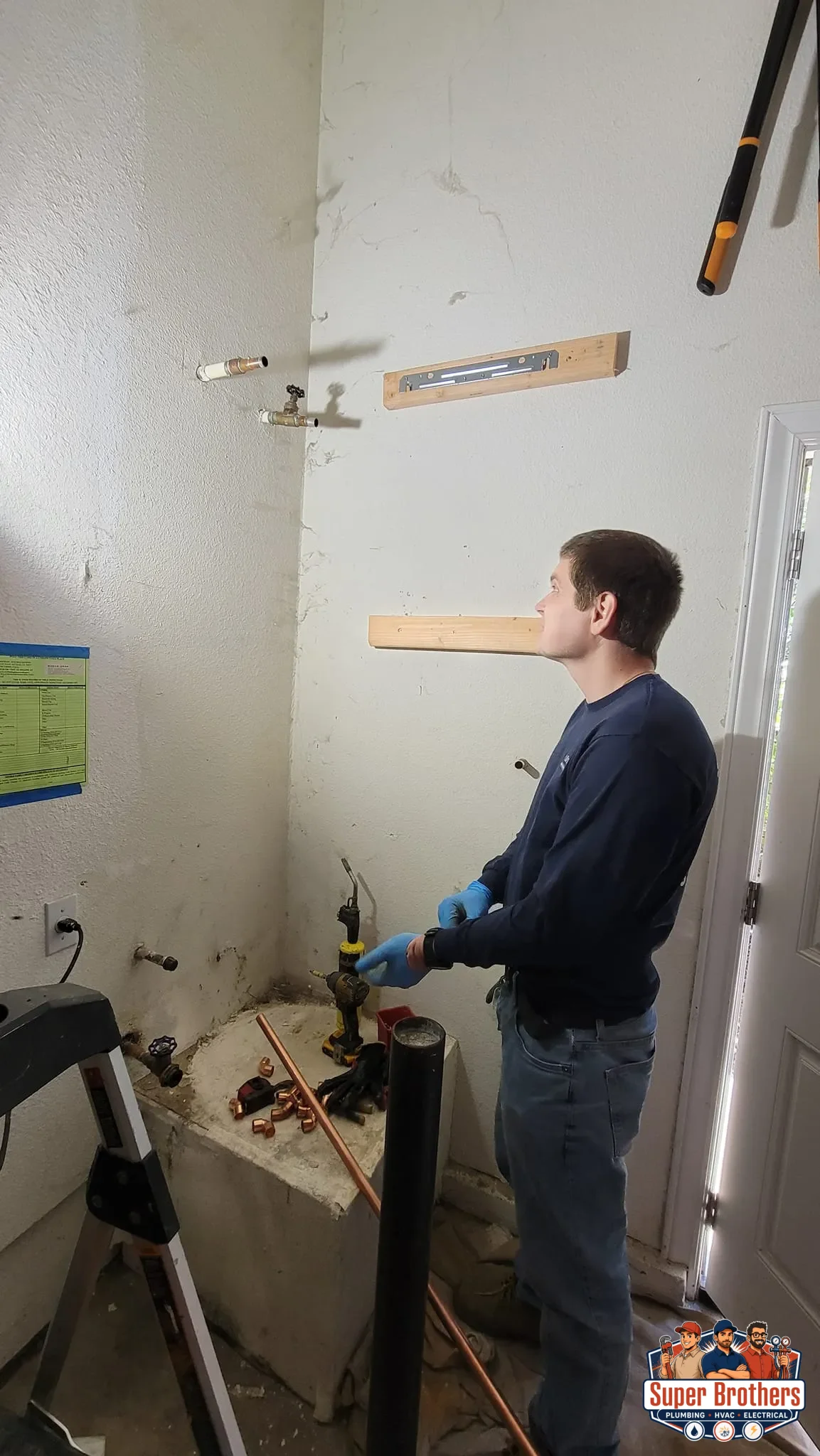Plumber measuring water heater connections for a tankless installation in Mountain View, CA