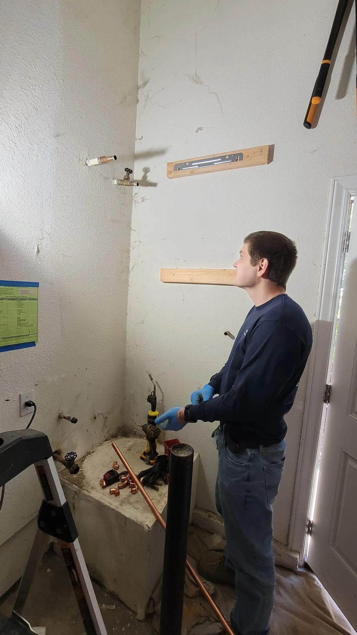 Plumber measuring water heater connections for a tankless installation in Mountain View, CA