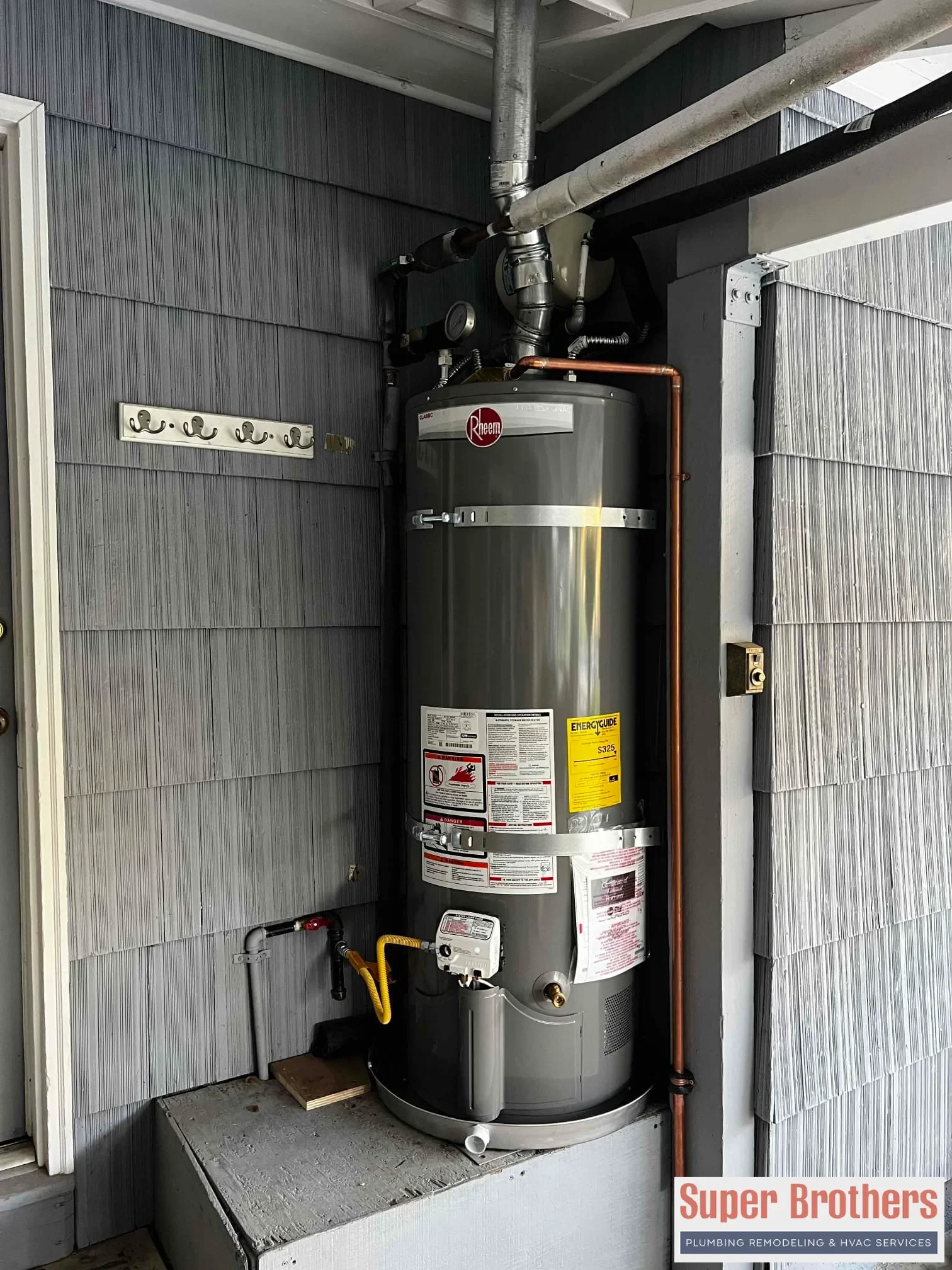 New hot water heater being installed with seismic straps and updated plumbing connections