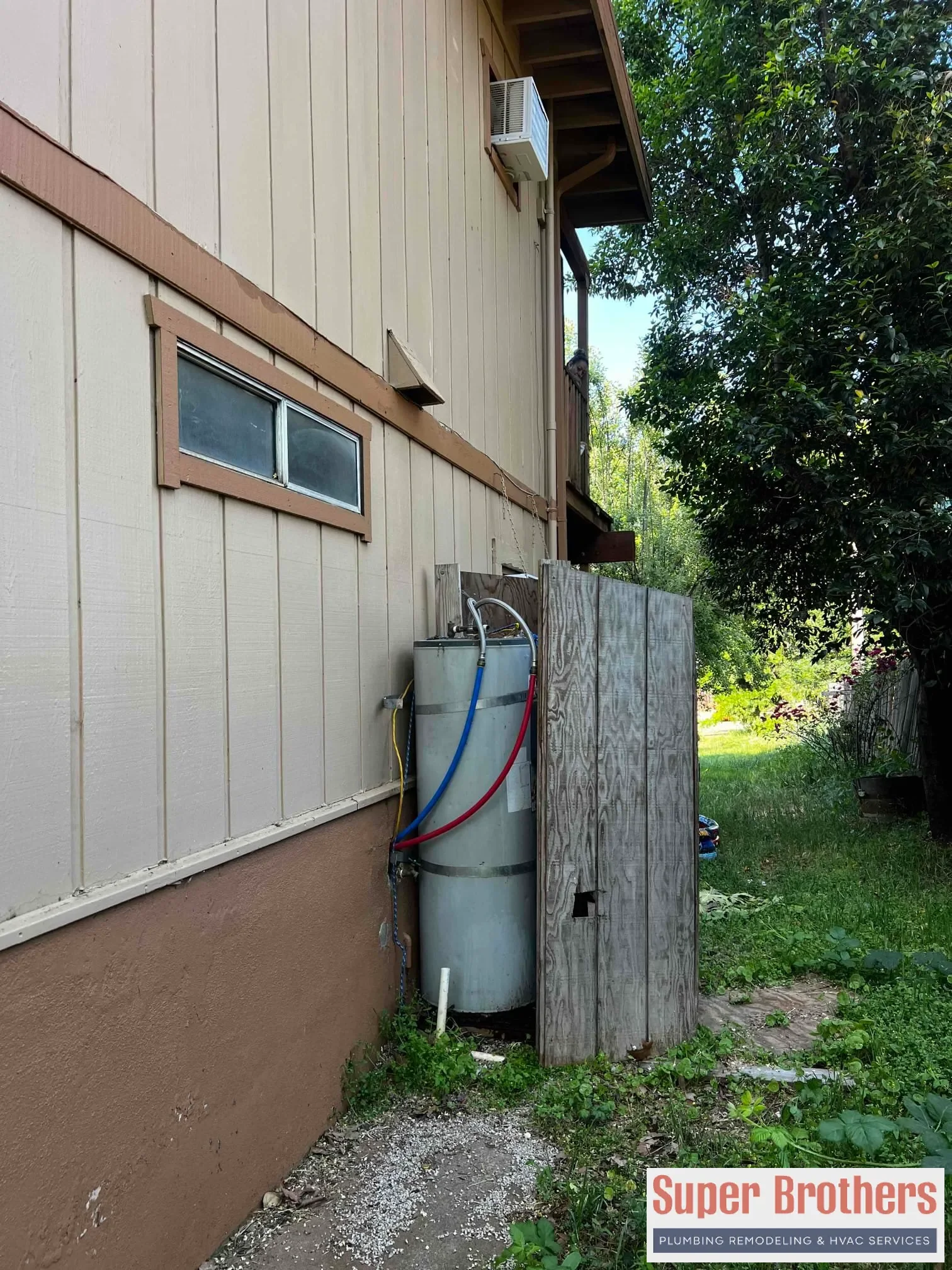 Plumber inspecting corrosion and leak signs on an older water heater