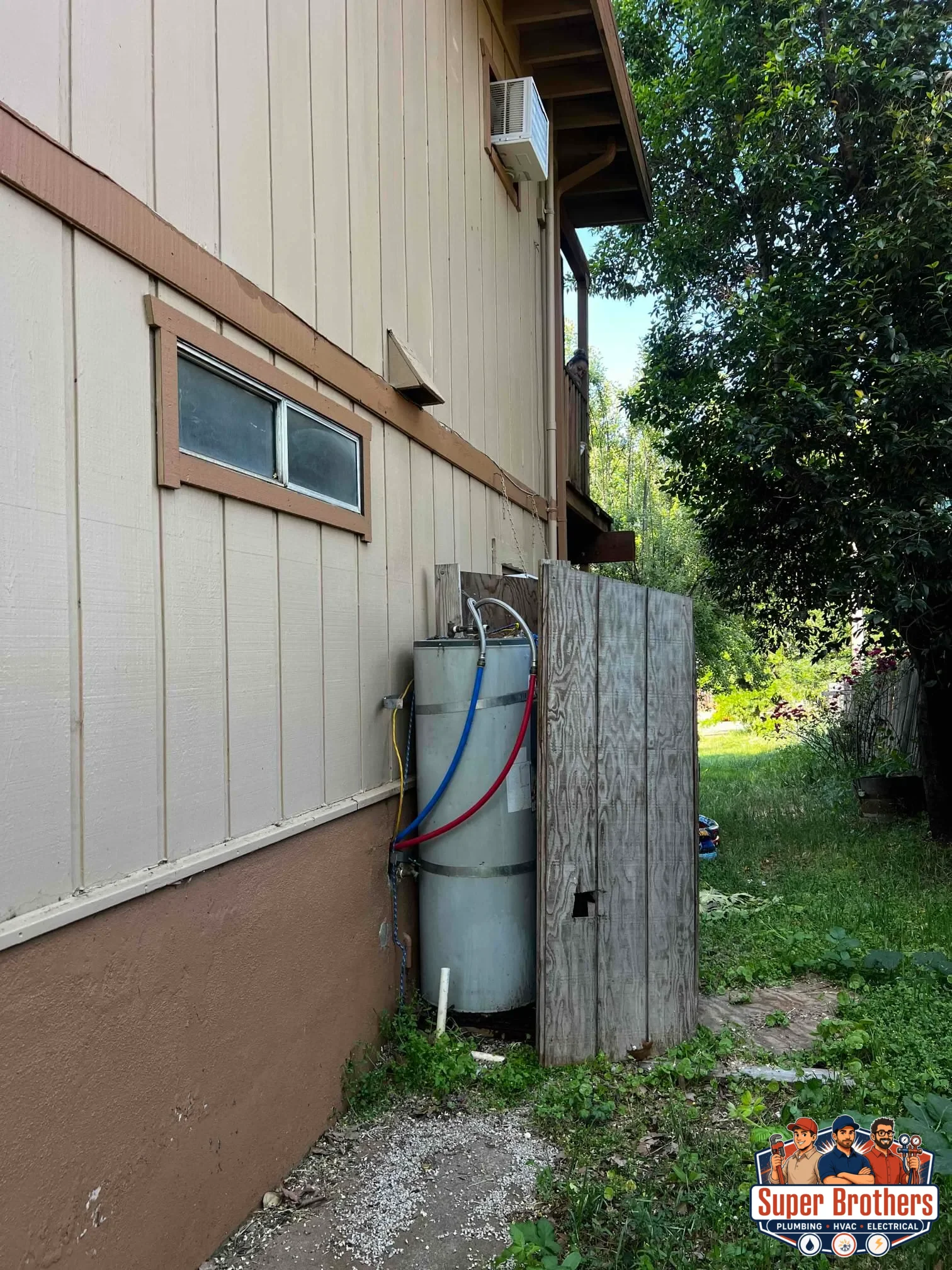 Plumber inspecting corrosion and leak signs on an older water heater