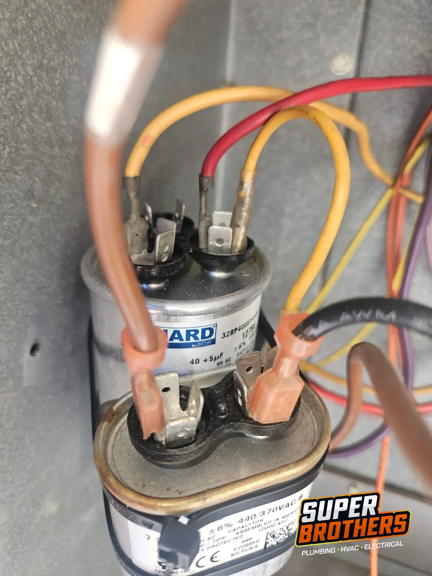 two capacitors and wiring inside rooftop packaged AC electrical cabinet two capacitors and wiring inside rooftop packaged AC electrical cabinet