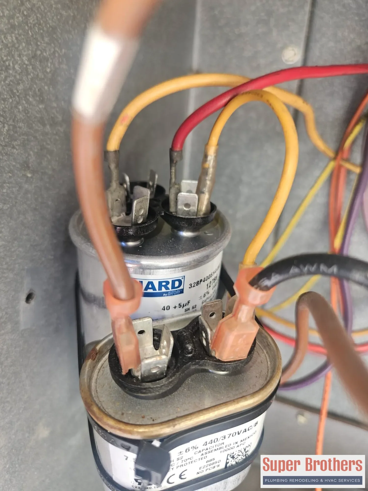 two capacitors and wiring inside rooftop packaged AC electrical cabinet two capacitors and wiring inside rooftop packaged AC electrical cabinet