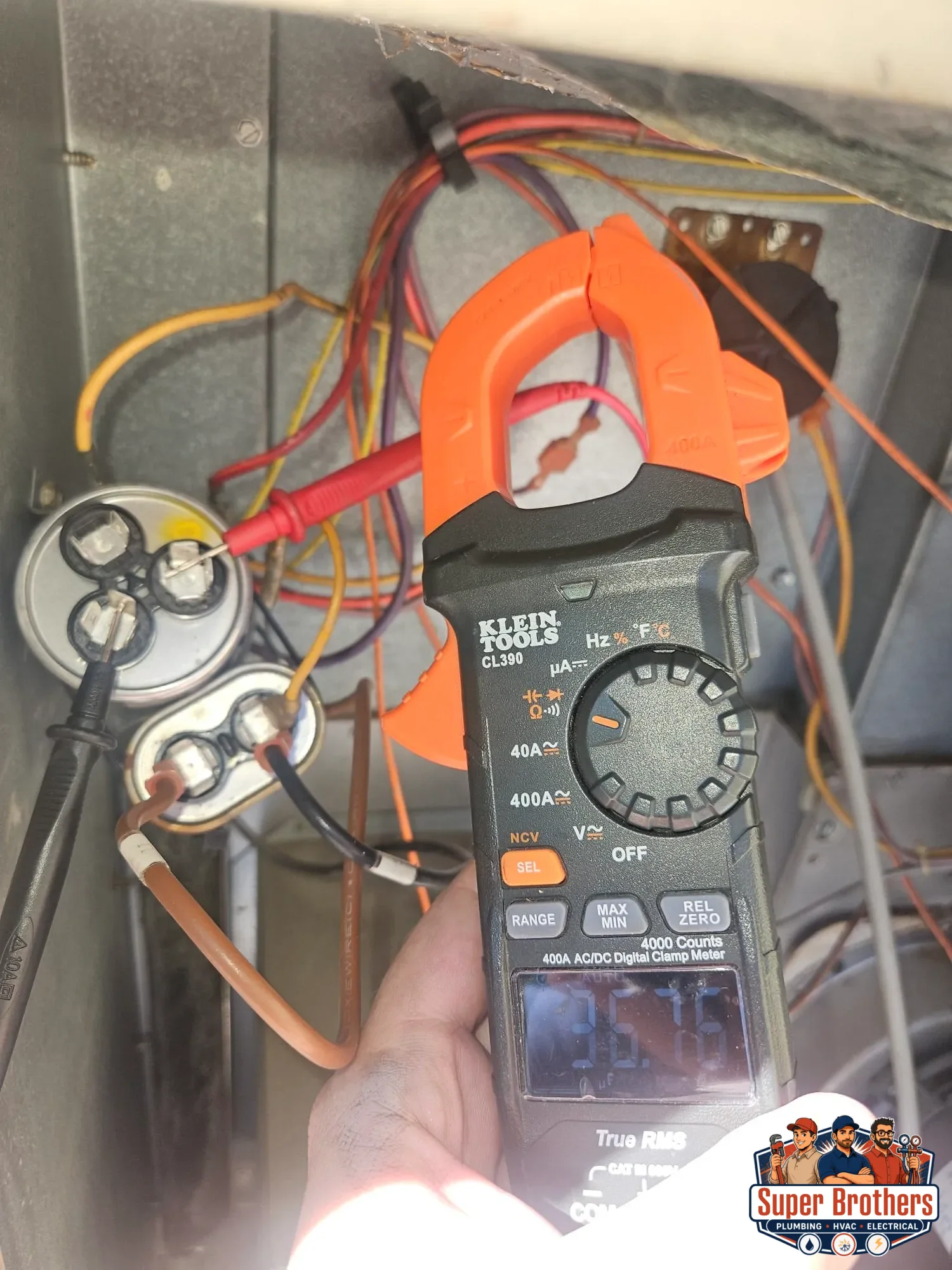 HVAC technician inspecting an AC capacitor in an outdoor unit in Northern California