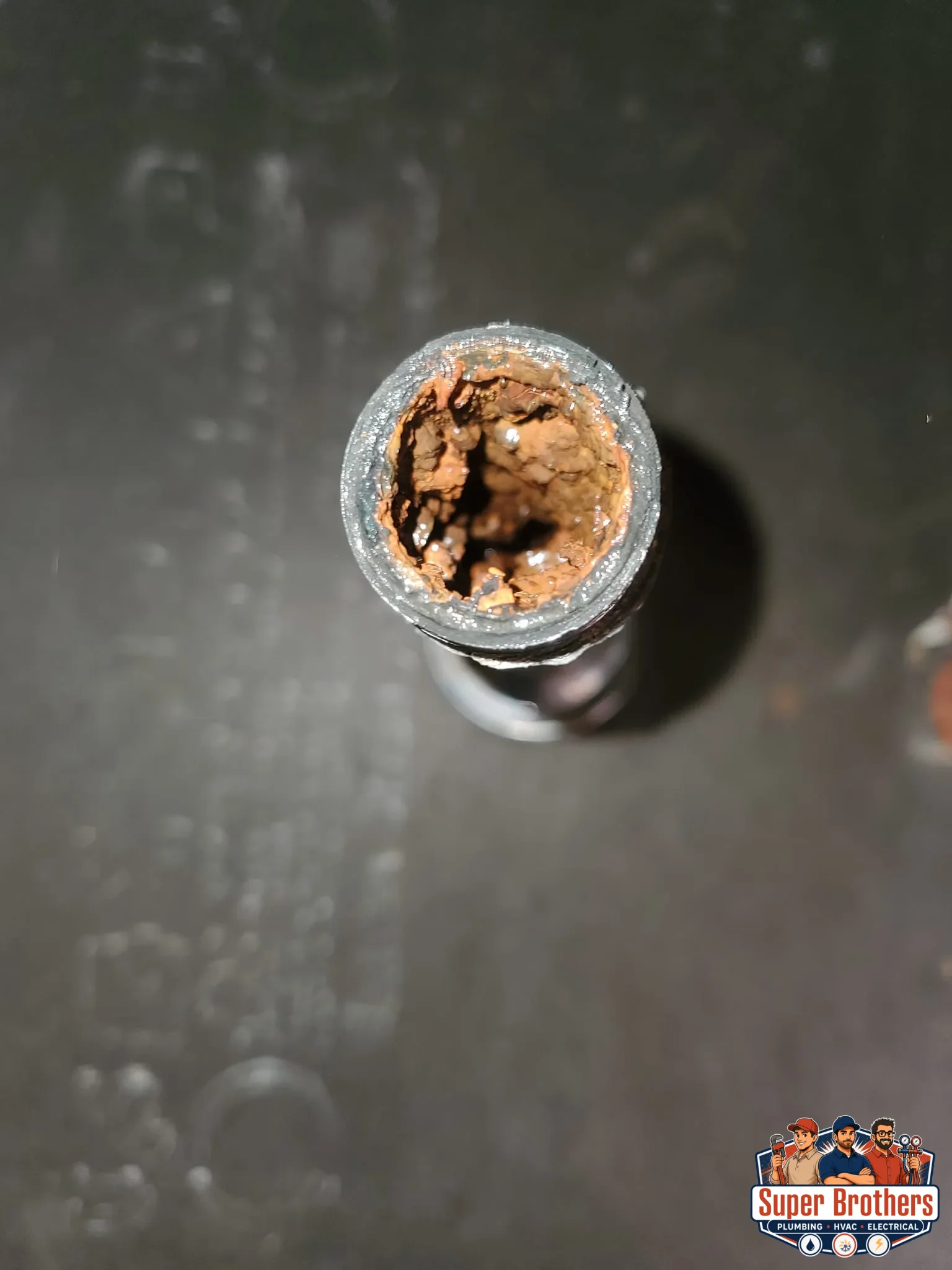 Rust and moisture around a connection on an old galvanized water pipe