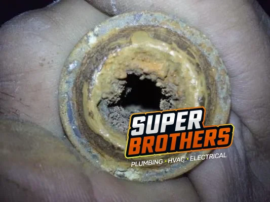 Clogged galvanized water pipe with buildup restricting the opening
